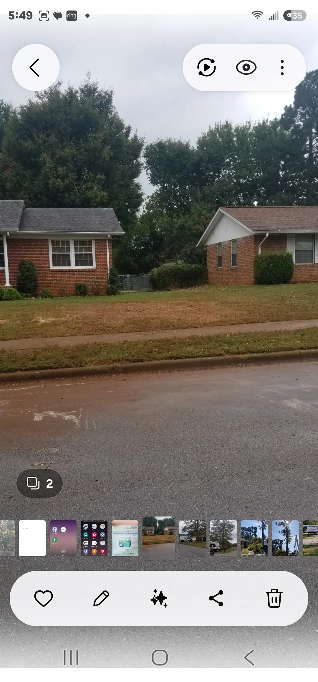 Cleared residential lot with brick homes, fresh mulch, and manicured landscaping