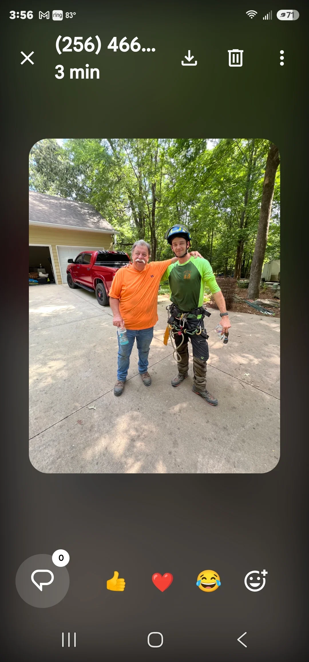 Tree service technician in safety gear with homeowner on residential driveway